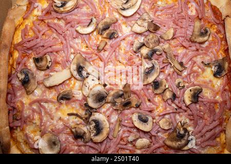 Une délicieuse pizza Capricciosa de Suède avec du fromage fondu, du jambon salé et des champignons tendres, capturés d'en haut pour mettre en valeur son attrait intemporel Banque D'Images