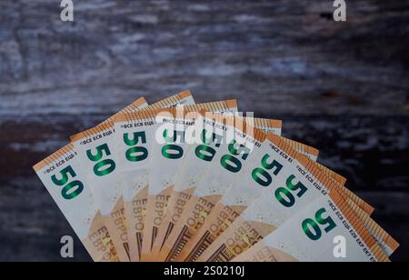 Un éventail d’euros présente une pile de billets de 50 euros sur une surface en bois. Banque D'Images