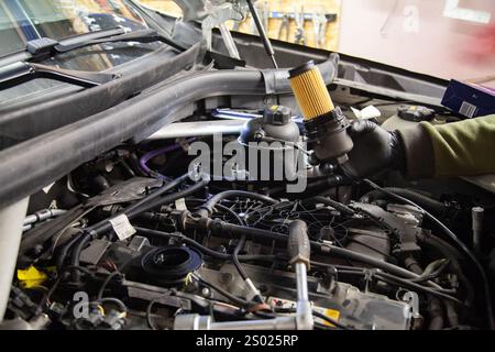 Mécanicien automobile travail sur le changement du filtre à huile dans BMW Banque D'Images