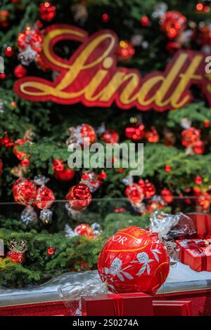 Zurich, Suisse - 24 novembre 2024 : arbre de Noël emblématique Lindt à Zurich SBB Hauptbahnhof orné d'ornements rouges et de décorations en chocolat Banque D'Images