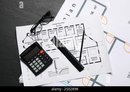 Différents dessins architecturaux, verres, calculatrice et règle sur table texturée grise, pose à plat Banque D'Images
