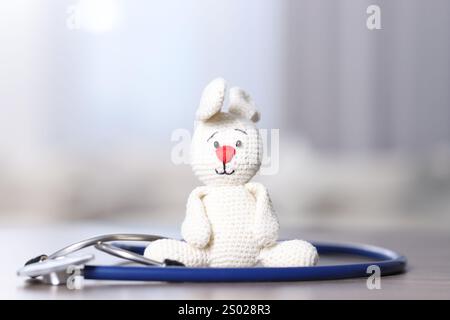 Concept pédiatrique. Lapin jouet avec stéthoscope sur table à l'intérieur Banque D'Images