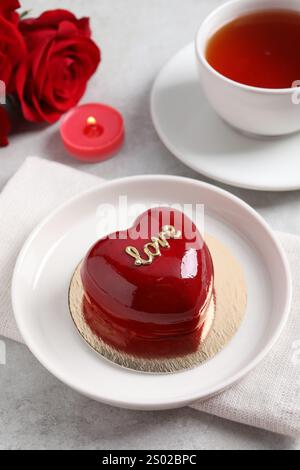 Prog Saint Valentin. Délicieux gâteau en forme de coeur servi sur une table lumineuse Banque D'Images