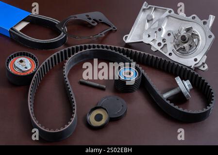 Pièces de rechange pour la voiture. Le jeu de courroie de distribution avec rouleaux et pompe de refroidissement sur une table de travail. Banque D'Images