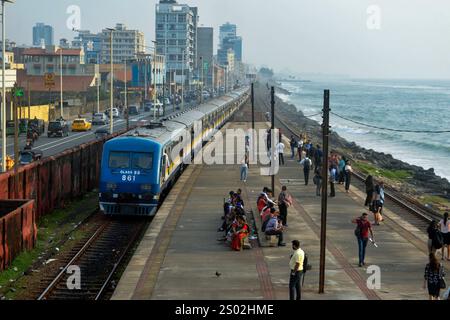 Colombo. 18 décembre 2024. Cette photo prise le 18 décembre 2024 montre un train en bord de mer à Colombo, Sri Lanka. La ligne de chemin de fer côtière, située sur la côte ouest du Sri Lanka et à proximité de l'océan Indien, est une ligne ferroviaire importante dans ce pays insulaire. C'est également une attraction touristique célèbre, où la côte droite, les calèches sans portes, et la belle vue sur la mer tout au long du voyage permettent aux gens d'obtenir l'expérience unique de style Ceylan. Crédit : Gayan Sameera/Xinhua/Alamy Live News Banque D'Images