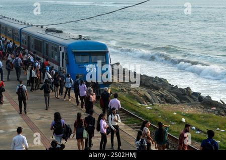 Colombo. 18 décembre 2024. Cette photo prise le 18 décembre 2024 montre un train en bord de mer à Colombo, Sri Lanka. La ligne de chemin de fer côtière, située sur la côte ouest du Sri Lanka et à proximité de l'océan Indien, est une ligne ferroviaire importante dans ce pays insulaire. C'est également une attraction touristique célèbre, où la côte droite, les calèches sans portes, et la belle vue sur la mer tout au long du voyage permettent aux gens d'obtenir l'expérience unique de style Ceylan. Crédit : Gayan Sameera/Xinhua/Alamy Live News Banque D'Images