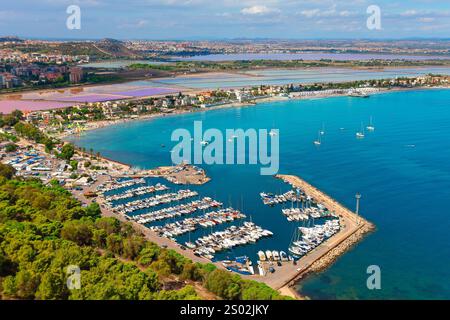 Vue aérienne de Cagliari, en Sardaigne, montrant la marina animée remplie de yachts, eaux turquoises et pittoresque ville côtière. Salines et lointaines Banque D'Images