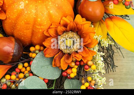 Couronne d'automne de feuilles jaunes de citrouilles et de châtaignes sur fond en bois Banque D'Images