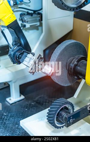 bras robotisé manipulant les pièces d'arbre usinées en métal polissant entre la ligne de production. procédé de fabrication de pièces automobiles. Banque D'Images