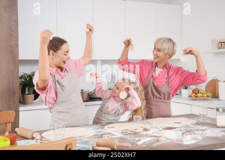 Famille heureuse avec des cercles de pâte dans la cuisine Banque D'Images