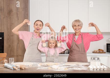 Famille heureuse avec des cercles de pâte dans la cuisine Banque D'Images