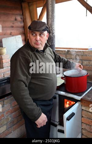 Ohrady, Dunajská Streda, Slovaquie - novembre 30 2024 : abattage de cochons de la communauté villageoise traditionnelle (zabíjačka), homme cuisinant le sang de cochon Banque D'Images