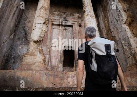 Touriste explorant la tombe d'Amyntas à Fethiye, Turquie Banque D'Images