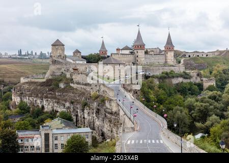 Un château avec un pont sur une rivière et quelques personnes marchant dessus. Le château est vieux et a beaucoup d'histoire Banque D'Images