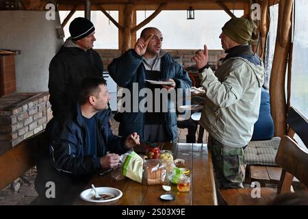 Ohrady, Dunajská Streda, Slovaquie - novembre 30 2024 : abattage de cochons de la communauté villageoise traditionnelle (zabíjačka), les hommes appréciant la nourriture et la conversation Banque D'Images