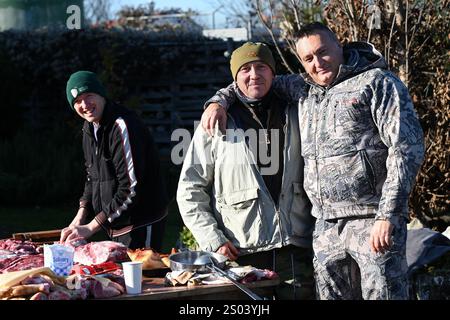 Ohrady, Dunajská Streda, Slovaquie - novembre 30 2024 : abattage de cochons de la communauté villageoise traditionnelle (zabíjačka), hommes heureux souriant à la caméra Banque D'Images