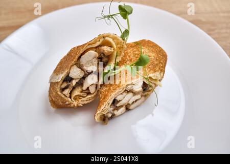 Crêpes fines fourrées d'une garniture salée de poulet et de champignons, garnies d'herbes fraîches. Banque D'Images