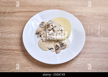 Sauce aux champignons onctueuse et crémeuse servie sur un lit de purée de pommes de terre moelleuses. Banque D'Images
