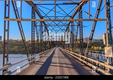 Un pont avec un panneau qui dit "danger" dessus. Le pont est long et a beaucoup de maillons de chaîne Banque D'Images