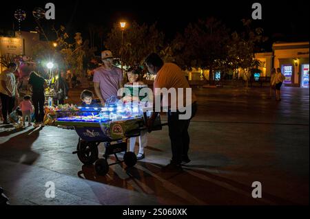 Une famille regarde les offres de nourriture sur le chariot d'un vendeur dans la soirée à la Plaza Mijares, la place principale dans la vieille ville de cette populaire Baja destinati Banque D'Images