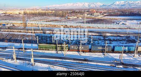 Horgos. 25 décembre 2024. Une photo de drone aérien prise le 25 décembre 2024 montre un train de marchandises Chine-Europe à destination du Kazakhstan passant par le port de Horgos à Horgos, dans la région autonome ouïgour du Xinjiang au nord-ouest de la Chine. Le port de Horgos, une plaque tournante ferroviaire majeure au Xinjiang, a facilité 8 541 voyages en train de marchandises Chine-Europe par Dec. 24 cette année, selon les statistiques du département ferroviaire du port de Horgos. Crédit : Wang Wenjie/Xinhua/Alamy Live News Banque D'Images