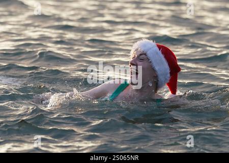 Les gens participent à la natation caritative annuelle de Noël du Clontarf Yacht and Boat Club en aide à la RNLI. Date de la photo : mercredi 25 décembre 2024. Banque D'Images