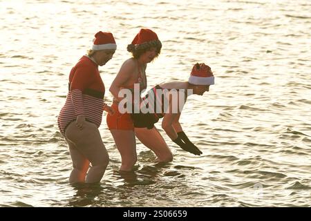 Les gens participent à la natation caritative annuelle de Noël du Clontarf Yacht and Boat Club en aide à la RNLI. Date de la photo : mercredi 25 décembre 2024. Banque D'Images