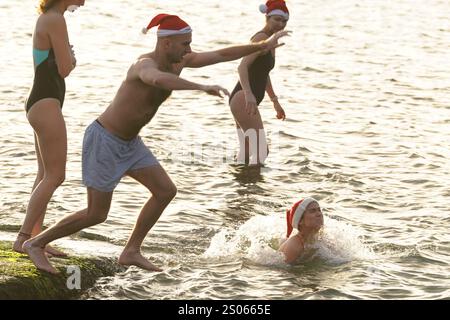 Les gens participent à la natation caritative annuelle de Noël du Clontarf Yacht and Boat Club en aide à la RNLI. Date de la photo : mercredi 25 décembre 2024. Banque D'Images