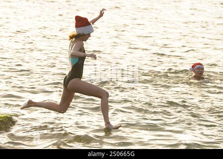 Les gens participent à la natation caritative annuelle de Noël du Clontarf Yacht and Boat Club en aide à la RNLI. Date de la photo : mercredi 25 décembre 2024. Banque D'Images