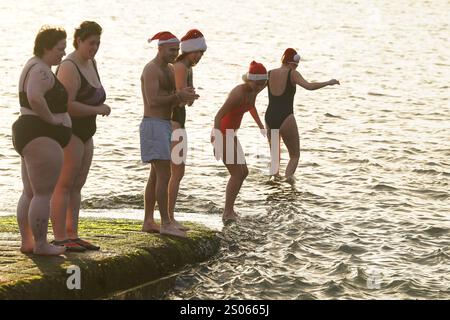 Les gens participent à la natation caritative annuelle de Noël du Clontarf Yacht and Boat Club en aide à la RNLI. Date de la photo : mercredi 25 décembre 2024. Banque D'Images