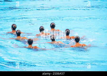 Équipe de nageurs artistiques exécutant une routine chorégraphiée synchronisée dans la piscine Banque D'Images