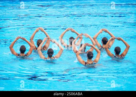 Équipe de natation artistique exécutant une routine chorégraphiée synchronisée en piscine Banque D'Images