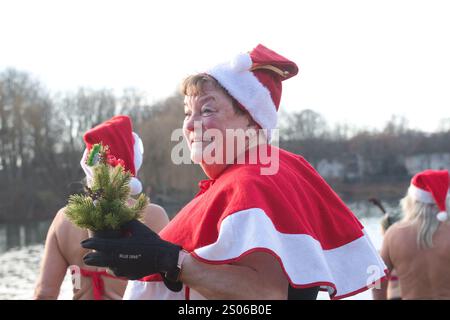 Berlin, Allemagne. 25 décembre 2024. Les membres de l'association 'Berliner Seehunde' partent pour une baignade de Noël dans l'Orankesee. Depuis plus de trente ans, les phoques de Berlin viennent à l'Orankesee pour la baignade sur glace le dimanche d'octobre à avril - les moments forts sont la baignade de Noël et le carnaval de la natation sur glace. Crédit : Paul Zinken/dpa/Alamy Live News Banque D'Images