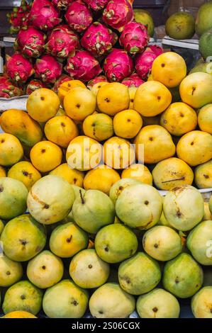 Une vitrine colorée de fruits faite de mangues et de fruits de dragon sur le marché local. Banque D'Images