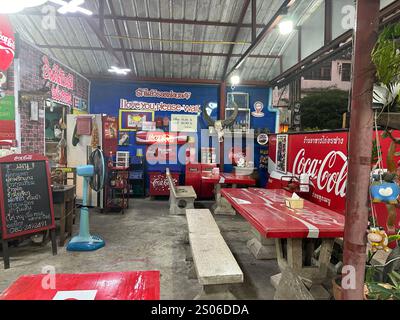 Un restaurant confortable avec des tables et des bancs en bois, orné d'un signe CocaCola vibrant affiché bien en évidence sur le mur Banque D'Images