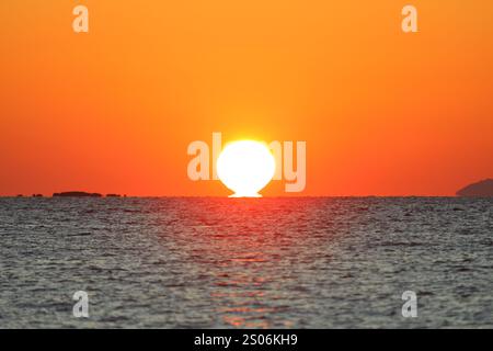 Gros plan du ciel vide et du soleil pour l'espace de copie. La vue spectaculaire sur le coucher de soleil était à couper le souffle, avec le soleil coulant derrière les nuages sur l'horizontale Banque D'Images