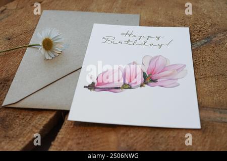 Carte de joyeux anniversaire avec une branche de magnolia peinte à l'aquarelle, avec une enveloppe en papier kraft, carte comme photo de produit en vente sur Etsy, décorée sur Banque D'Images