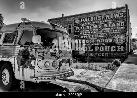 Vieux bus avec panneau fantôme sur un mur de briques dans le village de Palouse, État de Washington, États-Unis [pas de publication ; licence éditoriale uniquement] Banque D'Images