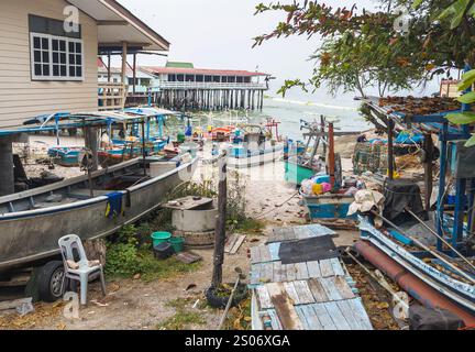 Petits bateaux en bois peints de couleurs vives, bric-a-Brac et huttes au bord de l'eau, surplombant d'autres jetées dépassant dans les mers du golfe de Thaïlande. Banque D'Images