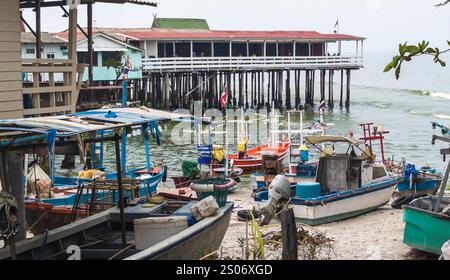 Petits bateaux en bois peints de couleurs vives, bric-a-Brac et huttes au bord de l'eau, surplombant d'autres jetées dépassant dans les mers du golfe de Thaïlande. Banque D'Images