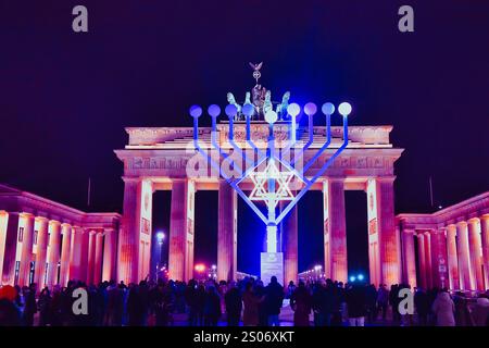Berlin, Allemagne. 25 décembre 2024. Au début de la fête juive des lumières de huit jours, Hanukkah, la première lumière brille sur le candélabre Hanukkah devant la porte de Brandebourg. Crédit : Paul Zinken/dpa/Alamy Live News Banque D'Images