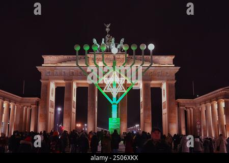 Berlin, Allemagne. 25 décembre 2024. Au début de la fête juive des lumières de huit jours, Hanukkah, la première lumière brille sur le candélabre Hanukkah devant la porte de Brandebourg. Crédit : Paul Zinken/dpa/Alamy Live News Banque D'Images