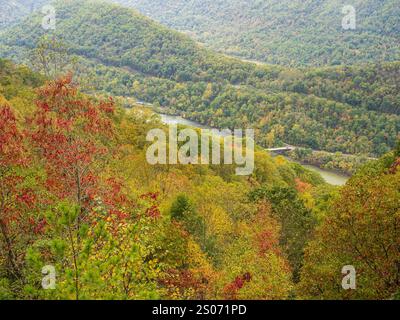 Les montagnes du parc national de New River gorge, couvertes de couleurs du début de l'automne, atteignent l'horizon, avec des ponts lointains ajoutant une touche d'archit Banque D'Images