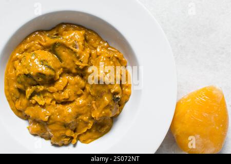 Vue aérienne de la soupe d'owo nigériane avec poisson et bœuf dans une assiette blanche, vue de dessus de la soupe d'oghwo dans une grande assiette Banque D'Images