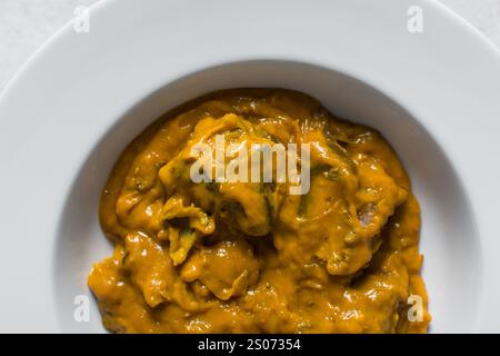 Vue aérienne de la soupe d'owo nigériane avec poisson et bœuf dans une assiette blanche, vue de dessus de la soupe d'oghwo dans une grande assiette Banque D'Images