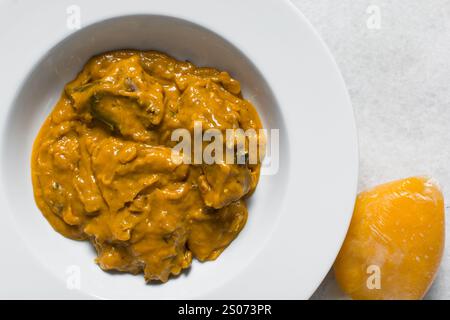 Vue aérienne de la soupe d'owo nigériane avec poisson et bœuf dans une assiette blanche, vue de dessus de la soupe d'oghwo dans une grande assiette Banque D'Images