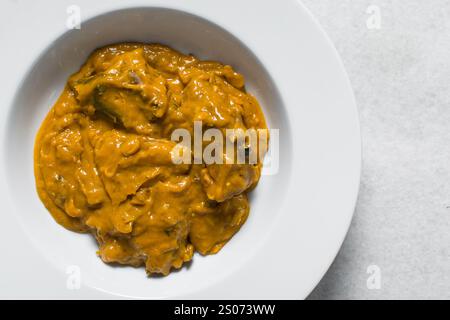 Vue aérienne de la soupe d'owo nigériane avec poisson et bœuf dans une assiette blanche, vue de dessus de la soupe d'oghwo dans une grande assiette Banque D'Images