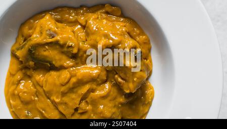 Vue aérienne de la soupe d'owo nigériane avec poisson et bœuf dans une assiette blanche, vue de dessus de la soupe d'oghwo dans une grande assiette Banque D'Images