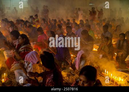 Les dévots s'assoient dans la prière avec de l'encens brûlants et des lampes à huile brillantes pendant Rakher Upobash, un festival de jeûne sacré, à l'Ashram i de Lokenath Brahmachari Banque D'Images