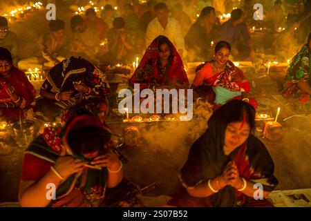 Les dévots s'assoient dans la prière avec de l'encens brûlants et des lampes à huile brillantes pendant Rakher Upobash, un festival de jeûne sacré, à l'Ashram i de Lokenath Brahmachari Banque D'Images